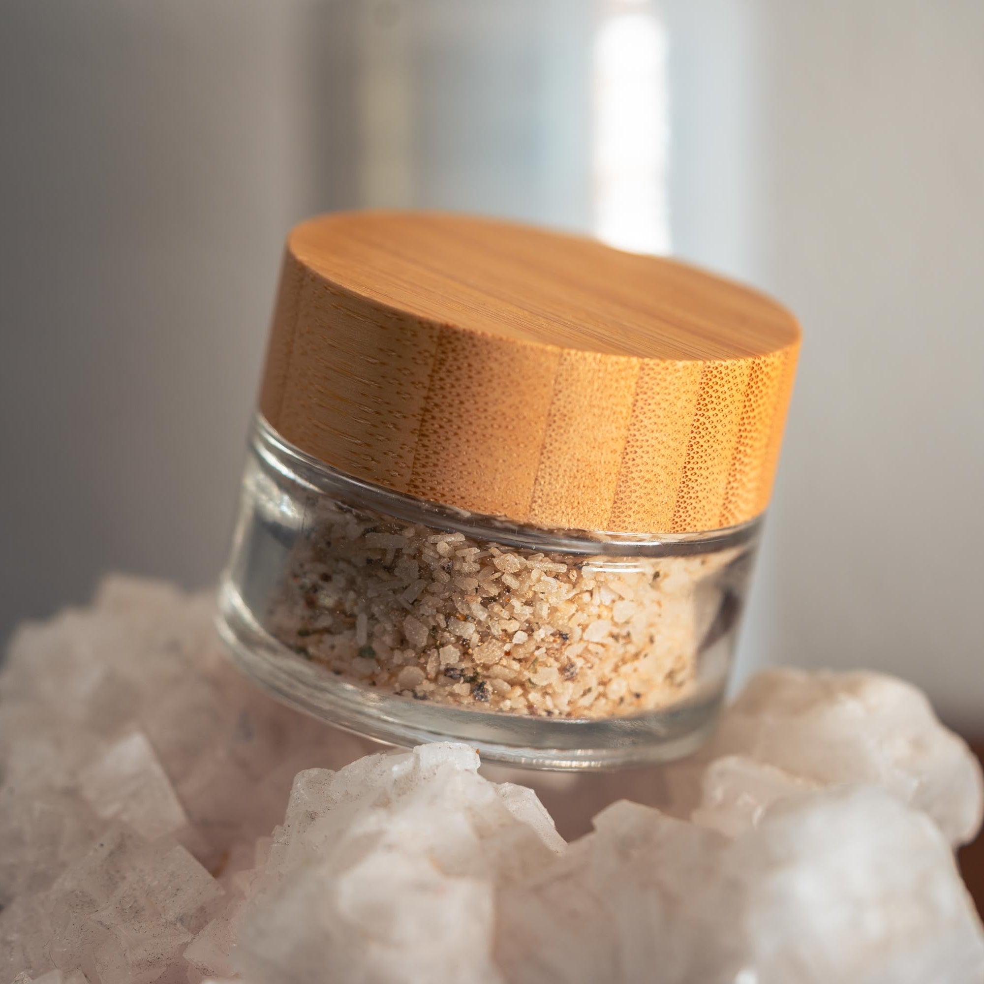 Glass jar with wooden lid on a white rock-like surface