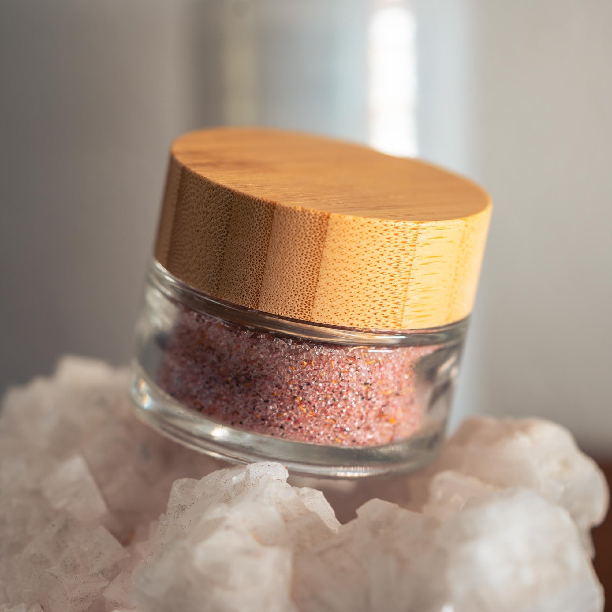 Glass jar with wooden lid on a rock with a blurred background